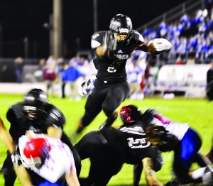 Aaron Mitchell takes the high road, jumping over a pack of Pace Patriots at last Friday night’s game in Navarre.  (Photo by Ken Garner | South Santa Rosa News)