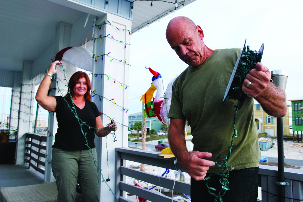 Jeanette and Al Seiders unravel one of many Christmas tree light strands, which are packed away in storage for most of the year, but come out shortly after Halloween. The couple’s home on Navarre Beach is adorned with thousands of lights and Christmas decorations each year.  (Photo by Mat Pellegrino | South Santa Rosa News)