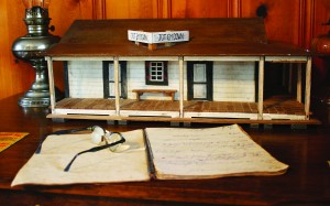 A detailed replica of the Jot ‘em Down store was created by the late Troy Grimes and presented to Betty Hawkins, one of Chanley and Mattie Tolbert’s grandchildren. Hawkins displays the model of the store in her home on top of Chanley’s desk along with the book he used to “jot down” credit and payment. His glasses are pictured on top of the receipt book. (Photo by Romi White | South Santa Rosa News)