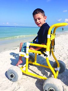 Six-year-old Kaden Grizzard was able to go out and nearly touch the ocean for the first time in his life Wednesday thanks to a chair he had donated to him by Stepping Stones for Stella. (Submitted Photo)