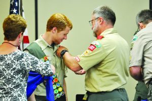 Caleb Dick is pinned by his father, David, at the Eagle Scout court of Honor ceremony.  (Photo by Mat Pellegrino | South Santa Rosa News)